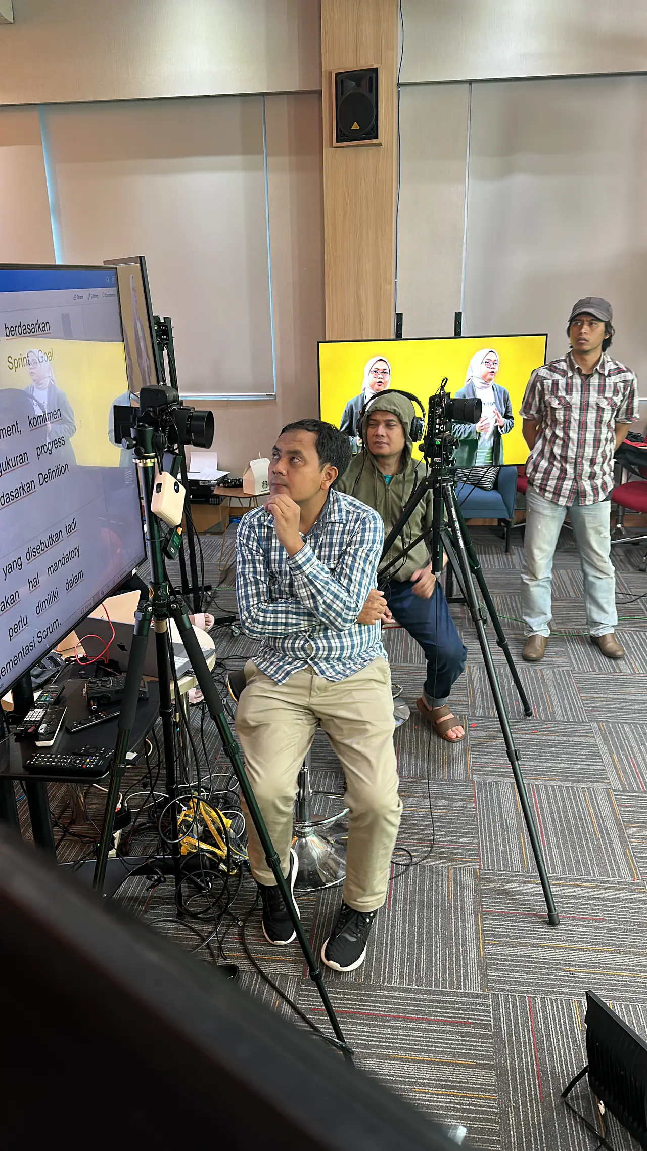 Kamera di atas rel slider mengarah ke narasumber yang duduk saat syuting di dalam ruangan.